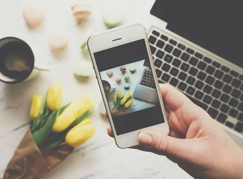 influencer taking photo with a smartphone of her desk